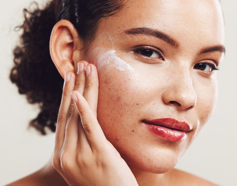 Femme applicant crème préventive pour acné, vieillissement cutané et problèmes de peau | ESI Show